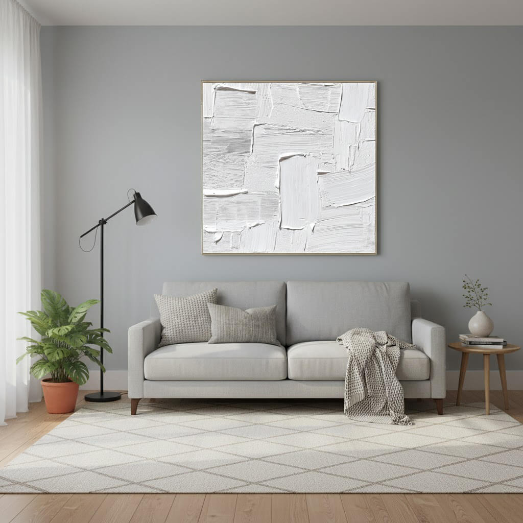 Modern living room with a gray sofa, abstract painting, and decorative items.