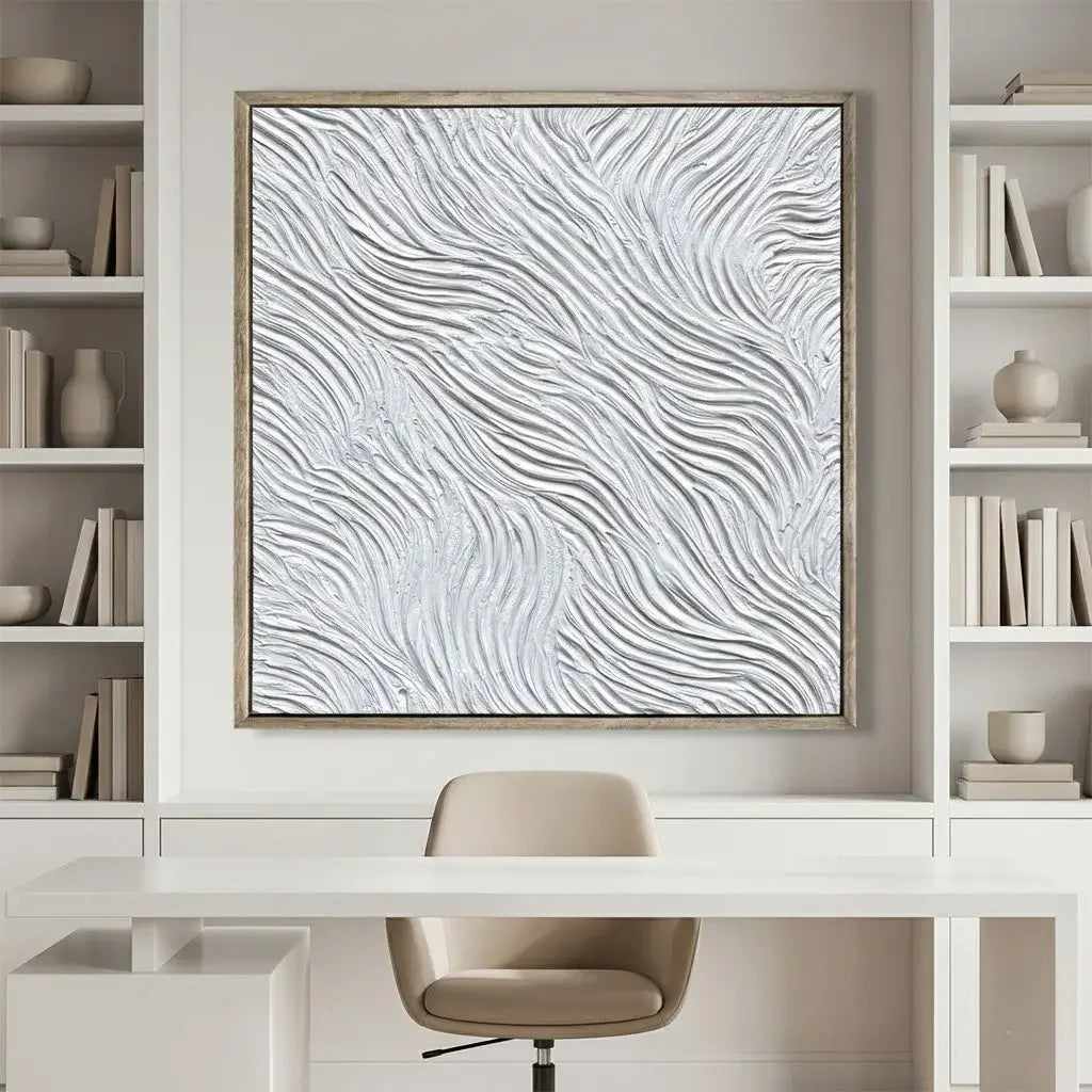 Abstract wall art in a modern office setting with bookshelves and a chair.
