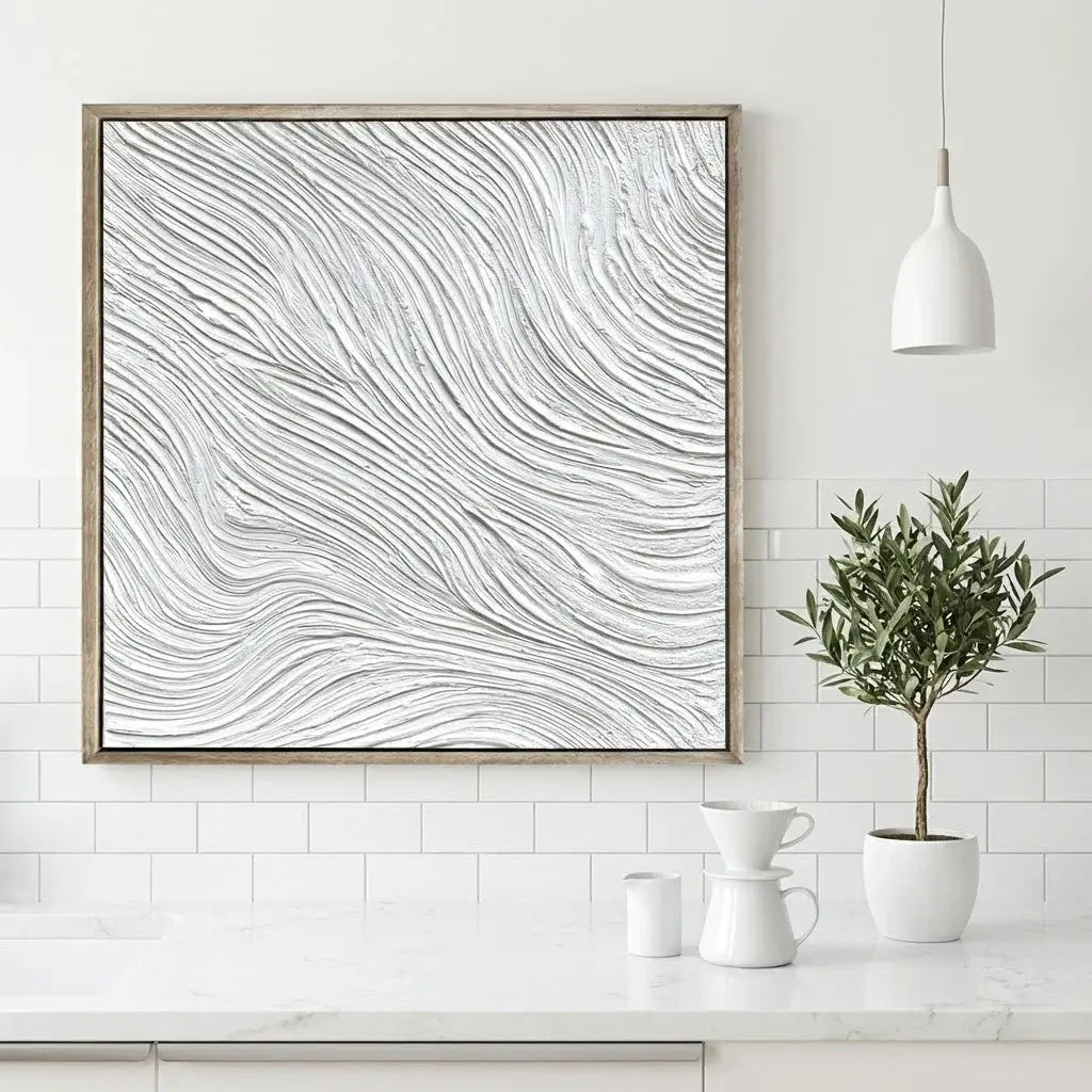 Abstract wall art with wavy lines in a wooden frame on a white wall above a kitchen counter.