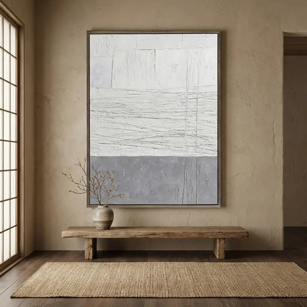 Abstract painting on a wall above a wooden bench in a room with natural light.