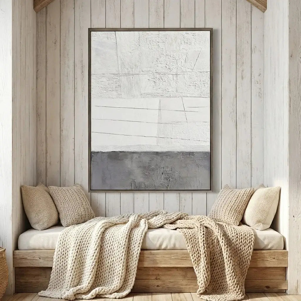 Cozy nook with a wooden bench, beige cushions, and a textured blanket against a wooden paneled wall with abstract art.