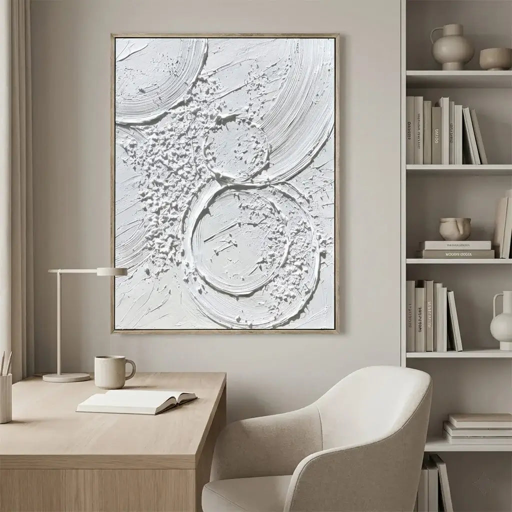 Modern office space with abstract wall art, desk, chair, and bookshelf.