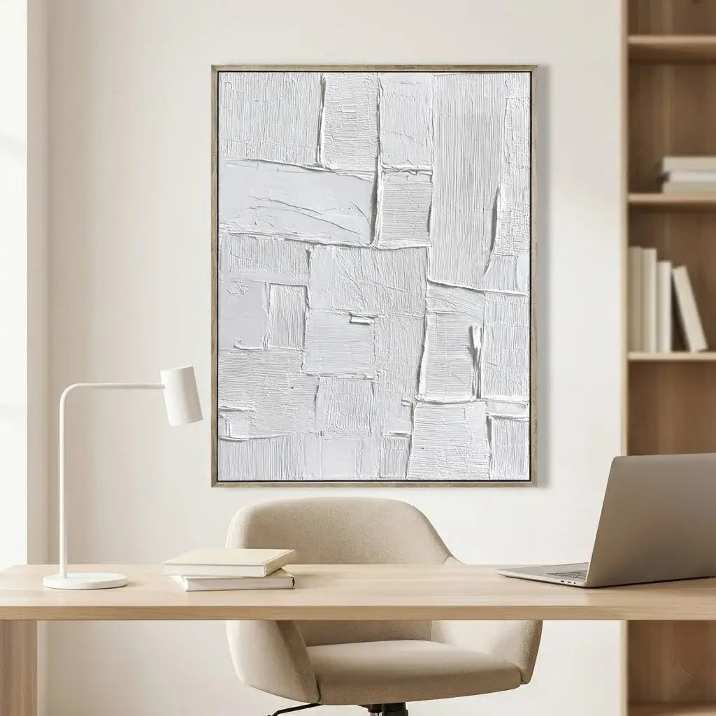 Modern office setup with a desk, chair, laptop, lamp, and abstract art on the wall.