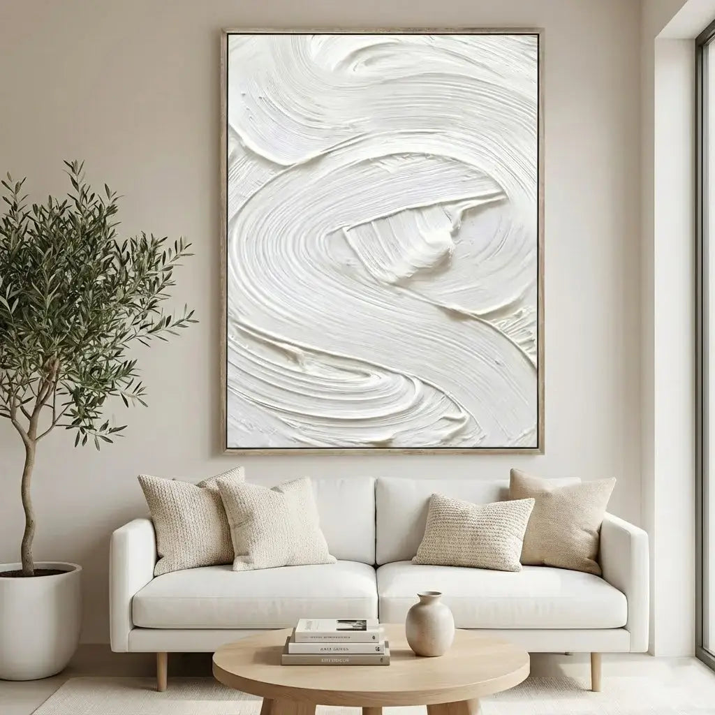 Modern living room with a white sofa, abstract art, and a plant.