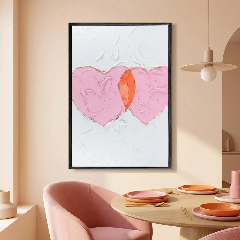 Dining room with abstract heart artwork on the wall, pink chairs, and a round table.