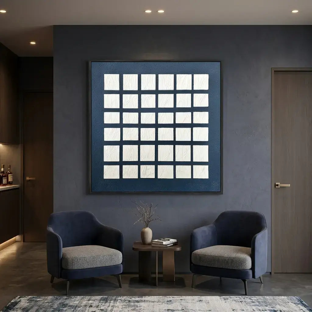 Modern living room with two blue armchairs, a small table, and a decorative wall art piece.