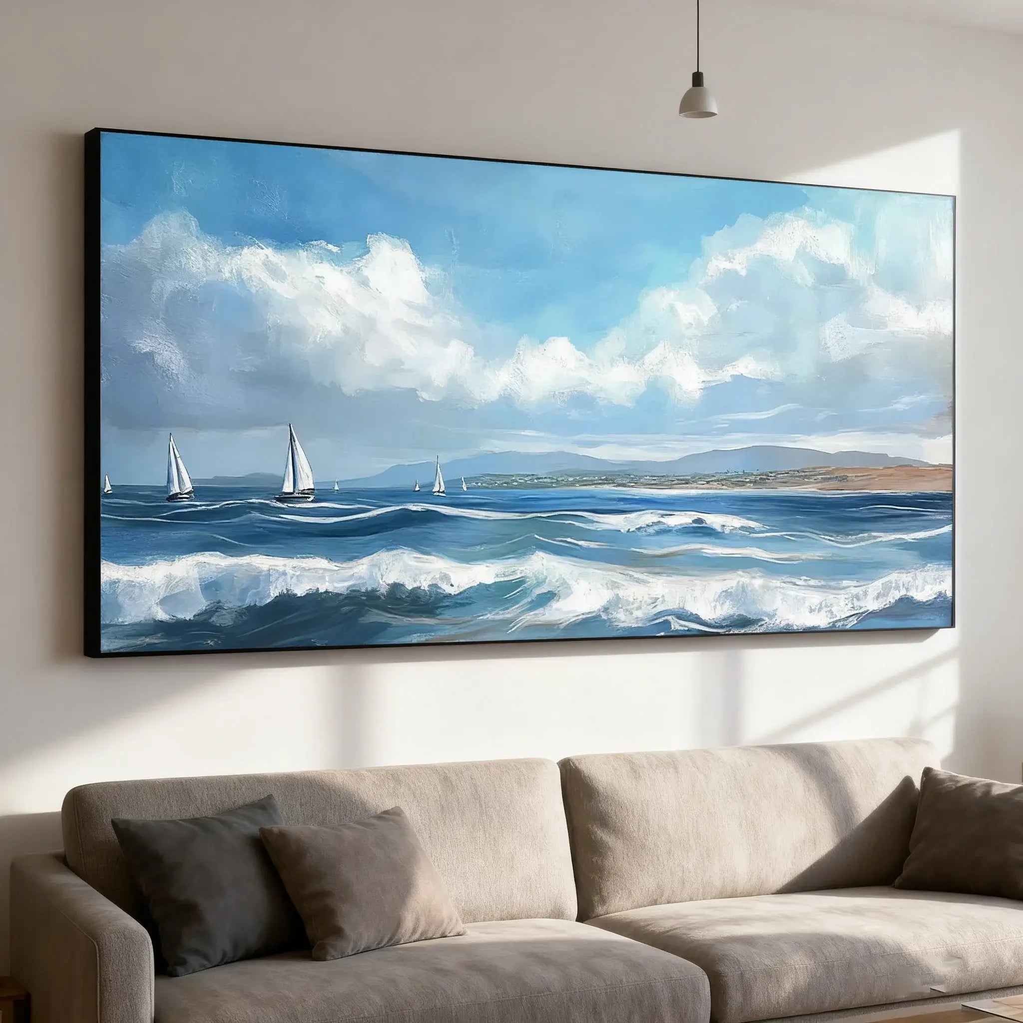 Large wall-mounted scenic painting of sailboats on the ocean, above a beige sofa.