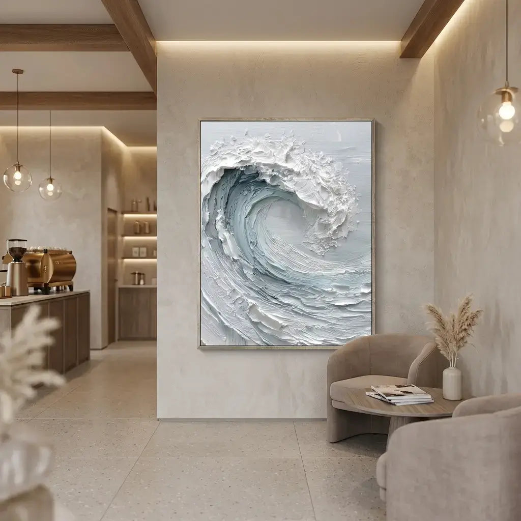 Modern interior with a wave painting on the wall, a round coffee table, and a kitchen area.