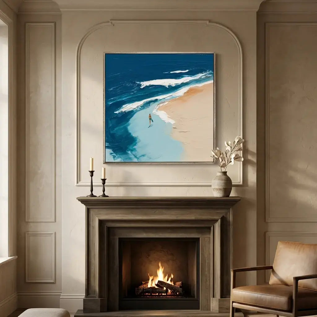 Beach scene painting above a fireplace in a room with a chair and decor.