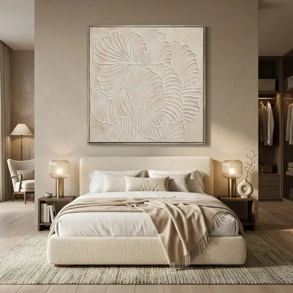 Neatly made bed in a bedroom with decorative wall art and lamps.