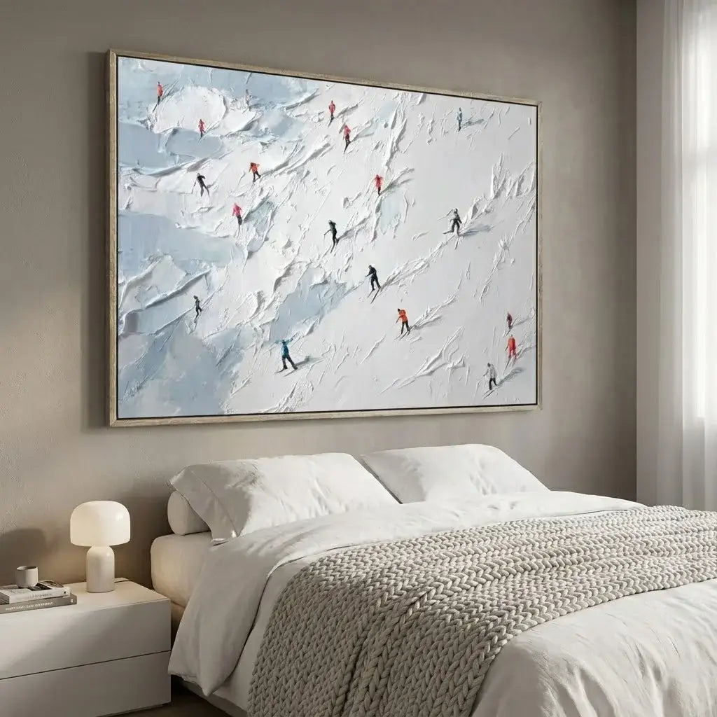 Bedroom with a large framed artwork of skiers on a mountain above a bed.