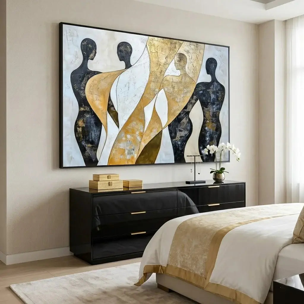 Modern bedroom with abstract art on the wall, black dresser, and bed with white and gold bedding.