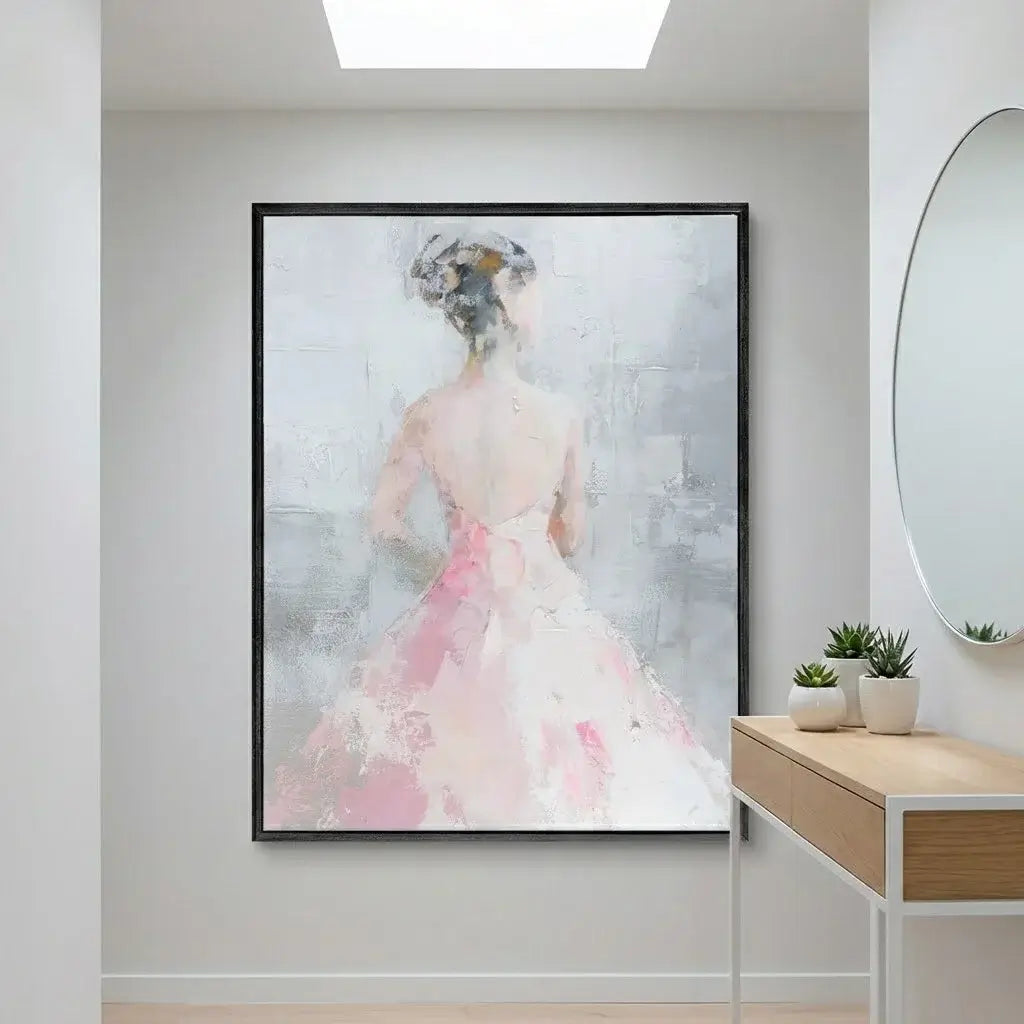 Framed abstract artwork of a woman in a pink dress on a wall in a modern interior setting.